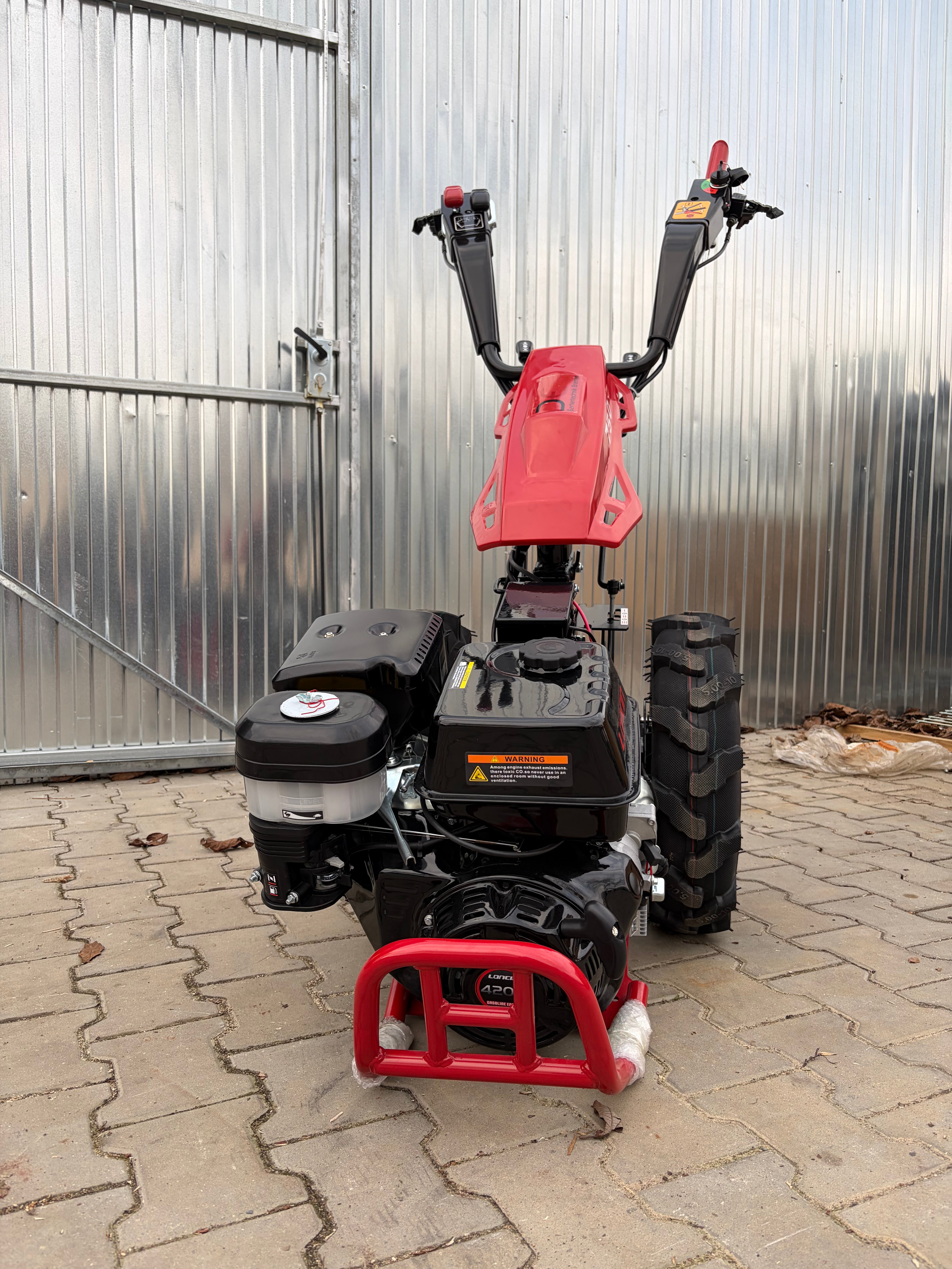 Koło z głębokim bieżnikiem i czerwoną felgą traktorka jednoosiowego Gartentechnik Bremen 750